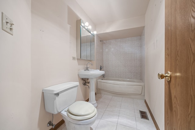 bathroom with tiled shower / bath combo, toilet, and tile patterned floors