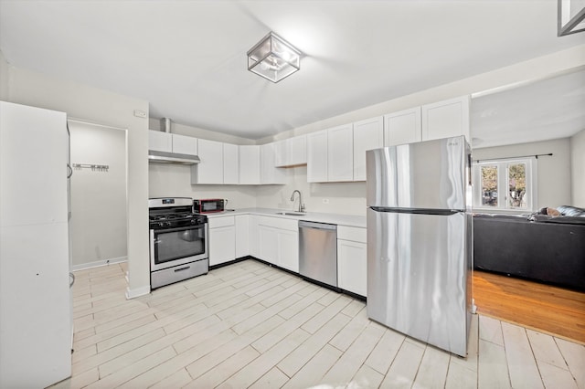 kitchen featuring stainless steel appliances, light wood-type flooring, and white cabinets