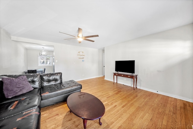 living room featuring lofted ceiling, hardwood / wood-style flooring, and ceiling fan with notable chandelier