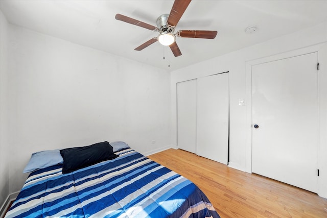 bedroom with a closet, light hardwood / wood-style floors, and ceiling fan