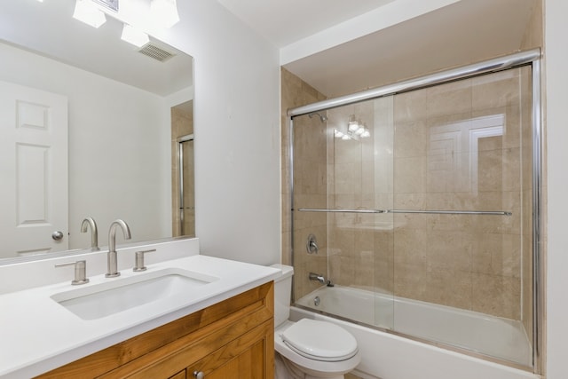 full bathroom with toilet, bath / shower combo with glass door, and vanity