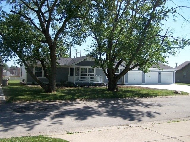 ranch-style house with a front lawn and covered porch