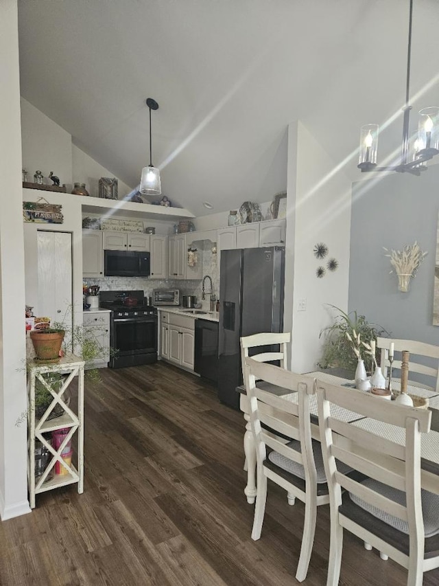 kitchen featuring hanging light fixtures, sink, black appliances, dark hardwood / wood-style floors, and decorative backsplash