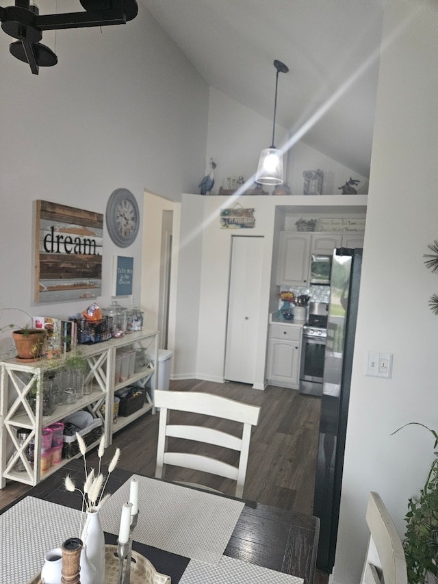 dining area featuring high vaulted ceiling, ceiling fan, and dark wood-type flooring