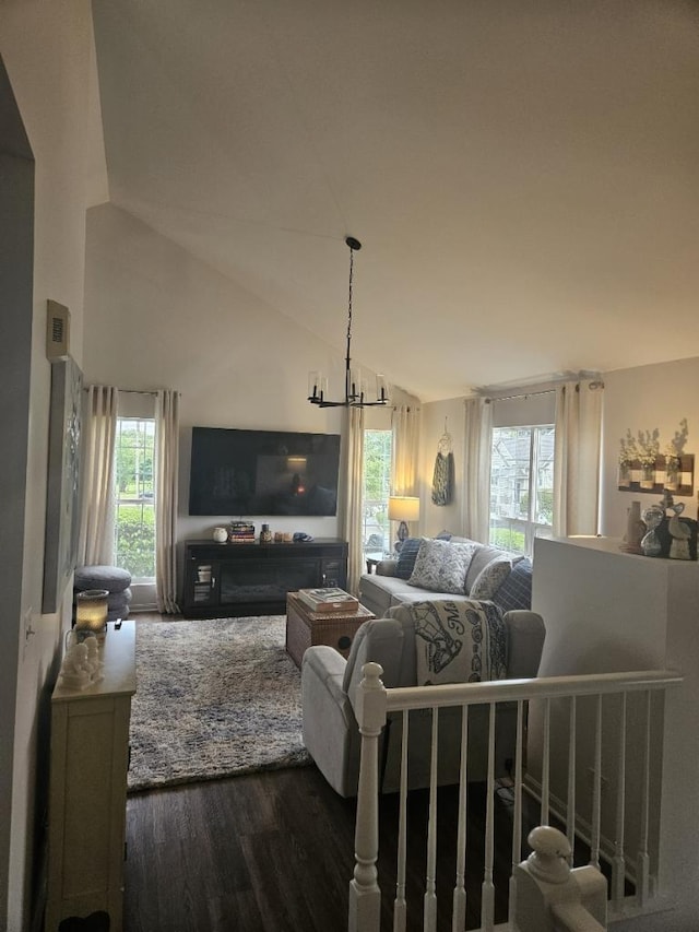 living room featuring a notable chandelier, lofted ceiling, and dark hardwood / wood-style floors