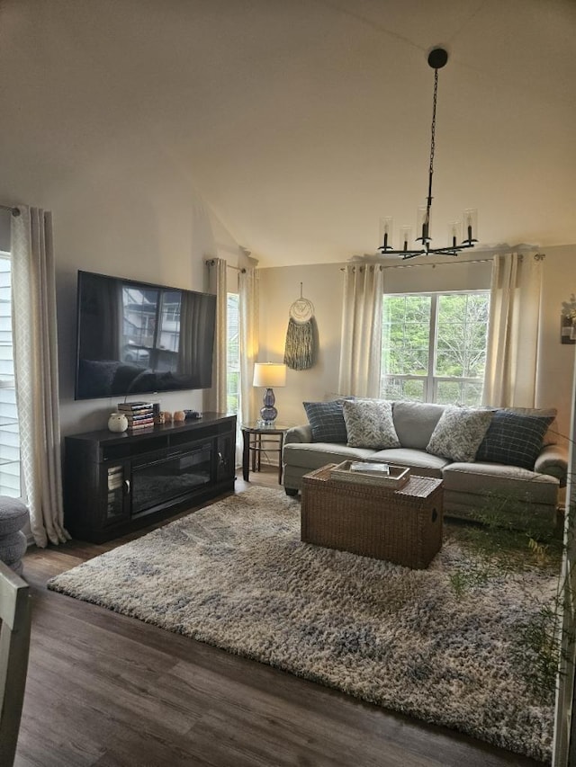 living room featuring an inviting chandelier, hardwood / wood-style floors, and high vaulted ceiling