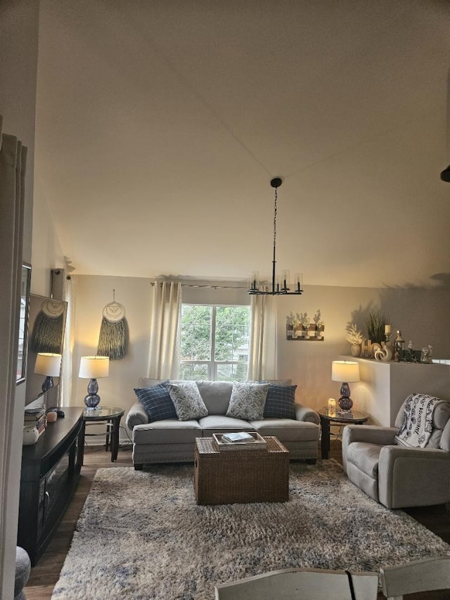 living room featuring vaulted ceiling, an inviting chandelier, and dark hardwood / wood-style flooring