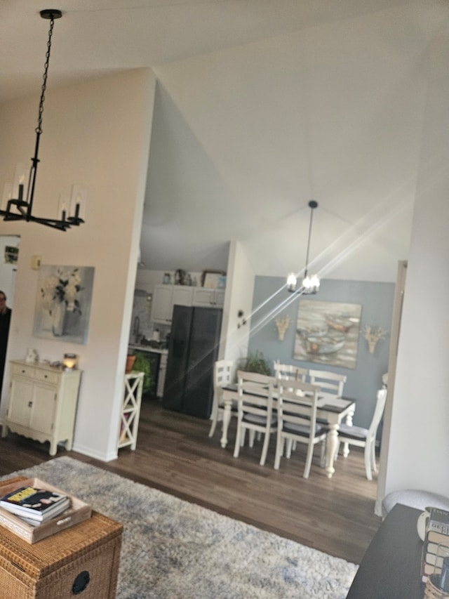 living room featuring a notable chandelier, high vaulted ceiling, and dark wood-type flooring