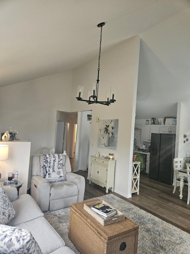 living room featuring high vaulted ceiling, a chandelier, and dark hardwood / wood-style flooring