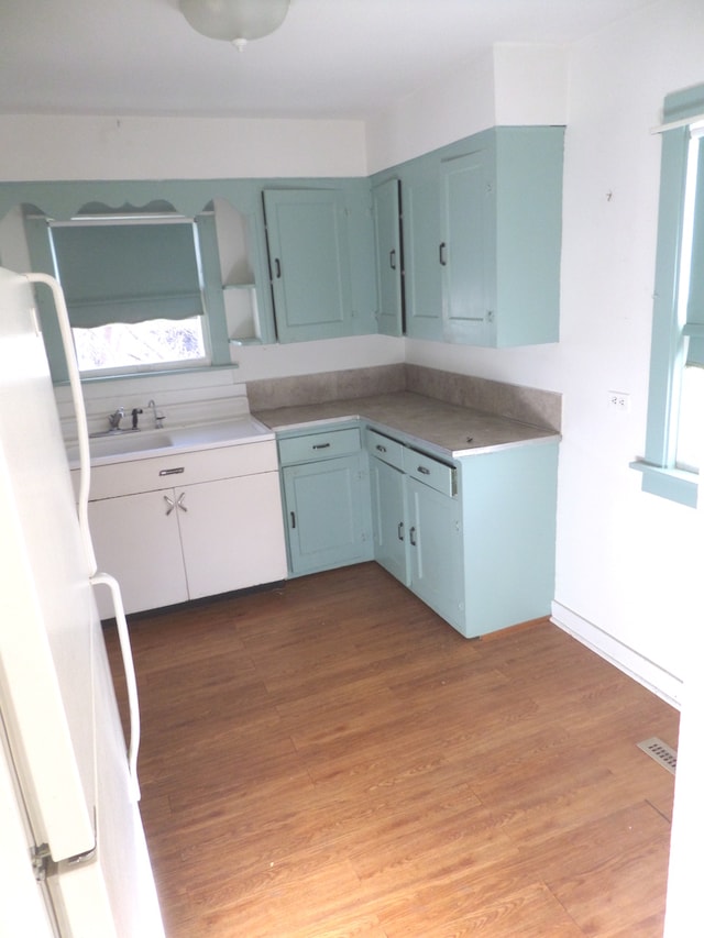 kitchen featuring white refrigerator, sink, and hardwood / wood-style floors