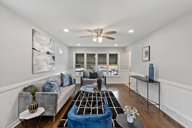 living room with dark hardwood / wood-style flooring and ceiling fan