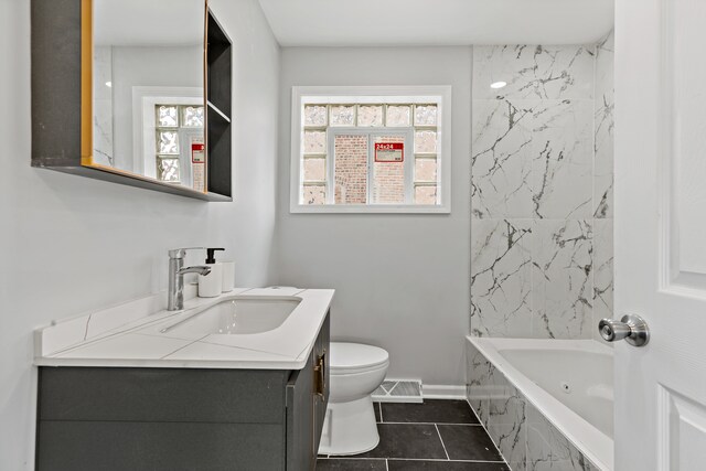 full bathroom featuring tile patterned floors, vanity, toilet, and tiled shower / bath combo