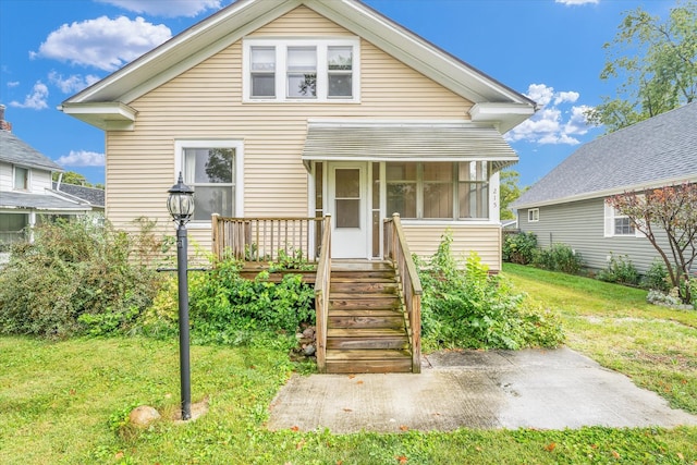 bungalow-style house featuring a front yard and a sunroom