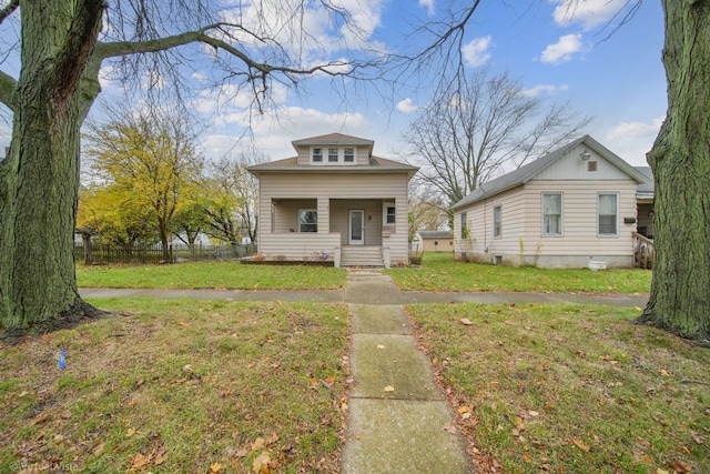 bungalow featuring covered porch and a front lawn