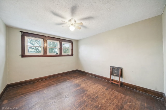 unfurnished room with ceiling fan, dark wood-type flooring, and a textured ceiling