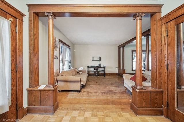 living room featuring light wood-type flooring and decorative columns