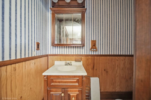 bathroom featuring wooden walls and vanity