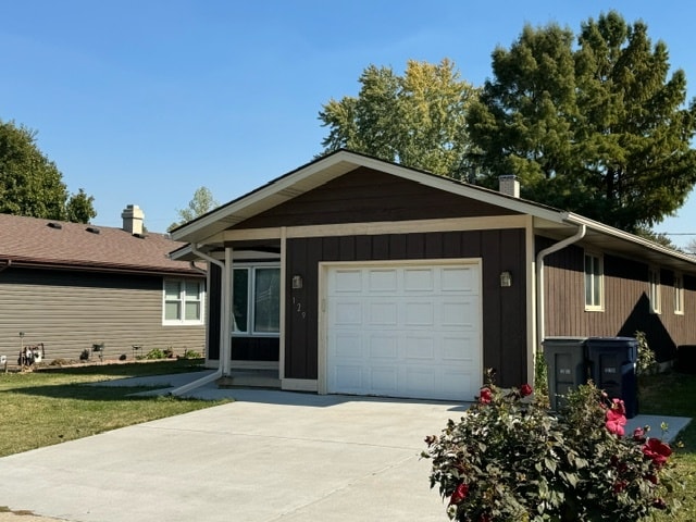 single story home with a garage and a front lawn