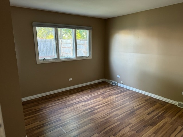 spare room featuring dark wood-type flooring