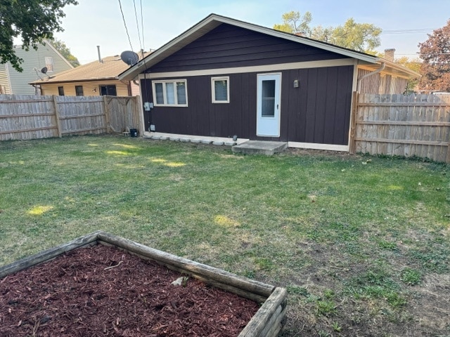 rear view of property featuring a lawn