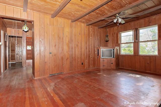 unfurnished living room featuring hardwood / wood-style flooring and wooden walls