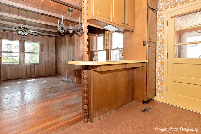 bar featuring wood walls, beamed ceiling, ceiling fan, wooden ceiling, and hardwood / wood-style flooring