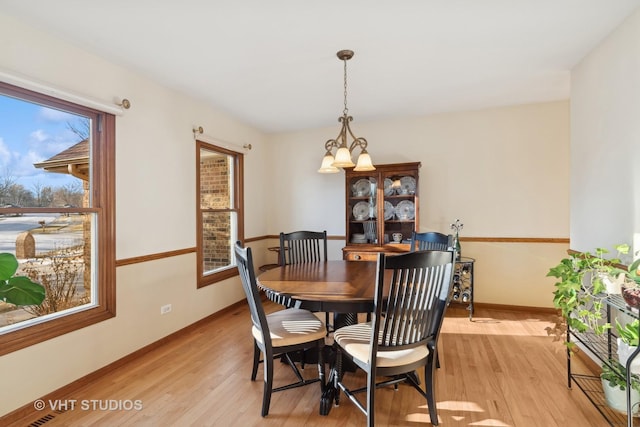 dining space with an inviting chandelier and light hardwood / wood-style floors