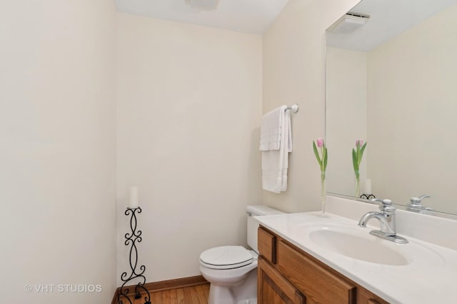 bathroom featuring vanity, hardwood / wood-style floors, and toilet