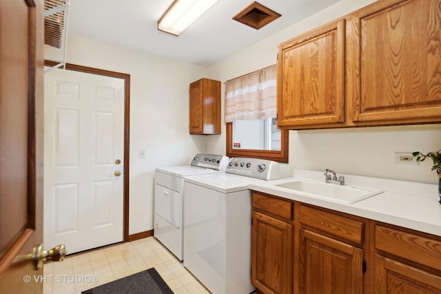 washroom with sink, cabinets, and washing machine and clothes dryer