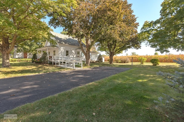 view of front of home featuring aphalt driveway, a front yard, and fence