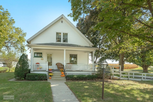 view of front facade with fence, a front lawn, and covered porch