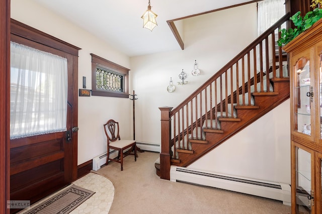 foyer entrance with carpet floors, a baseboard heating unit, and stairs
