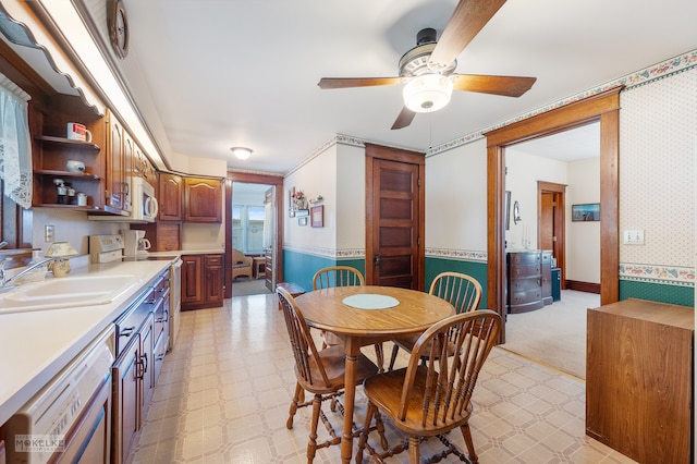 dining area with ceiling fan and sink