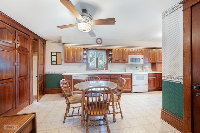 kitchen featuring white appliances, light countertops, wallpapered walls, and ceiling fan