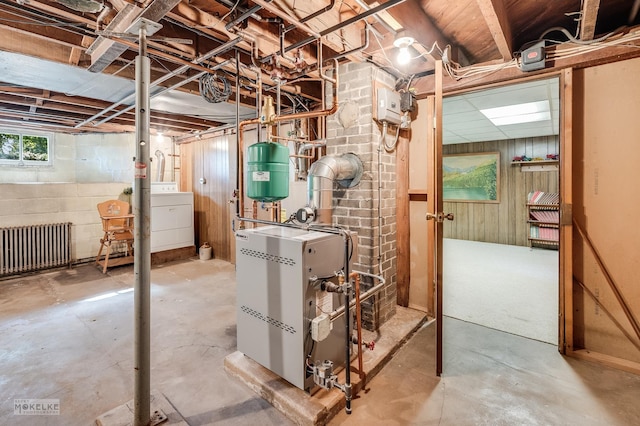 basement with radiator heating unit, wood walls, and a heating unit