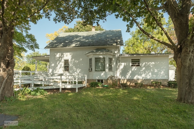 rear view of property with a yard and a deck