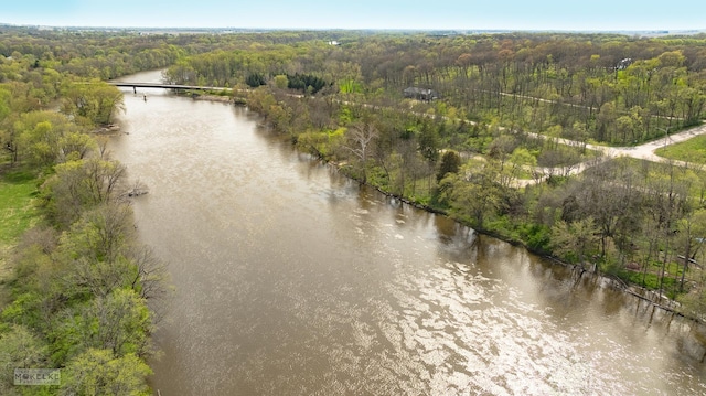 drone / aerial view with a forest view and a water view