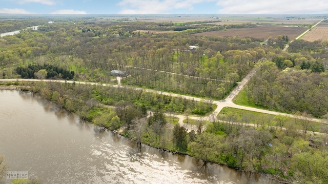 drone / aerial view featuring a water view and a forest view