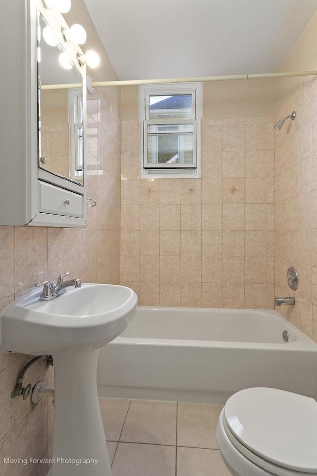 bathroom featuring tiled shower / bath combo, tile patterned floors, toilet, decorative backsplash, and tile walls