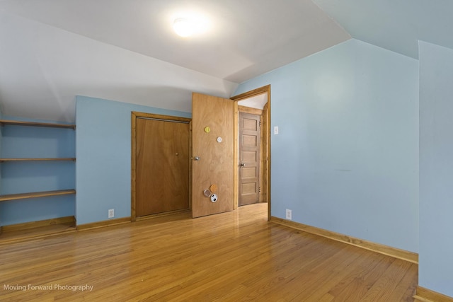 bonus room featuring light wood-type flooring and lofted ceiling