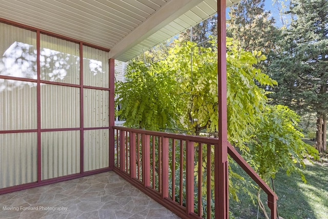 unfurnished sunroom featuring beamed ceiling