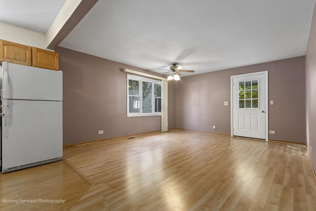 unfurnished living room featuring ceiling fan and light hardwood / wood-style flooring