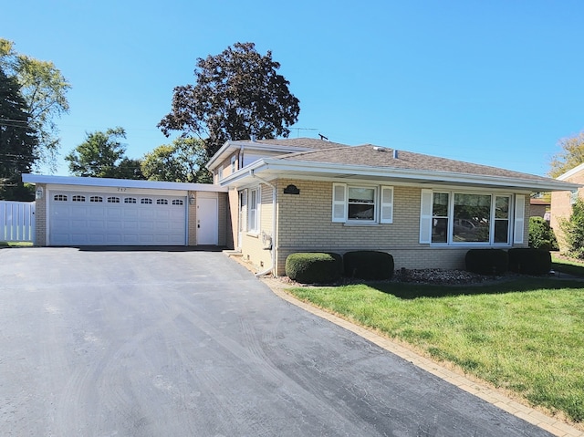 ranch-style home with a garage and a front lawn