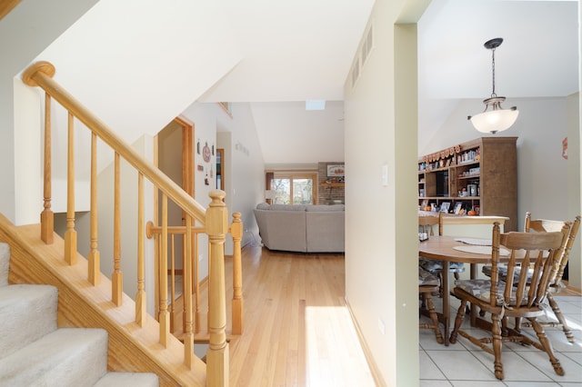 staircase featuring vaulted ceiling and hardwood / wood-style flooring