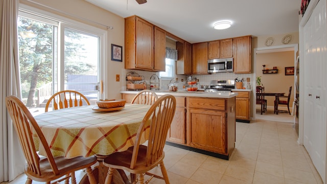 kitchen with tasteful backsplash, a healthy amount of sunlight, a center island, and stainless steel appliances