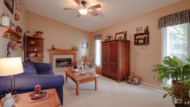 carpeted living room with ceiling fan and vaulted ceiling