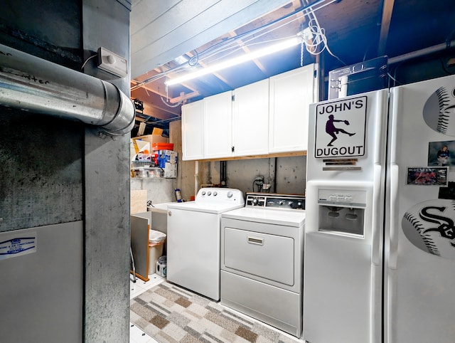 clothes washing area with cabinets and washer and clothes dryer