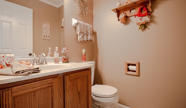 bathroom featuring vanity, toilet, and crown molding