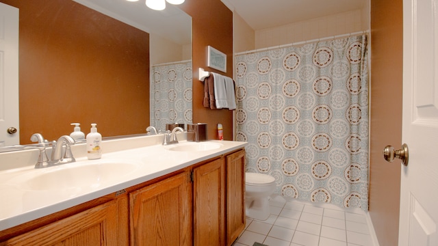 bathroom with toilet, vanity, and tile patterned floors