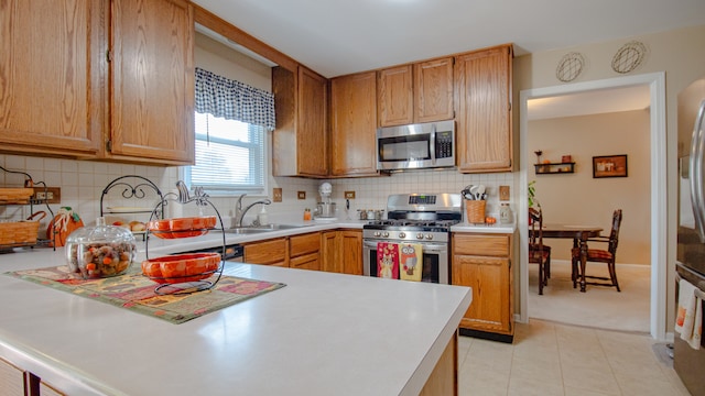 kitchen featuring decorative backsplash, sink, light tile patterned floors, and stainless steel appliances